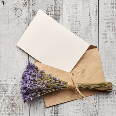 Davetiye kartı modeli ahşap arka planda lavanta çiçeği buketi, üst görünüm, boşluk kopyala