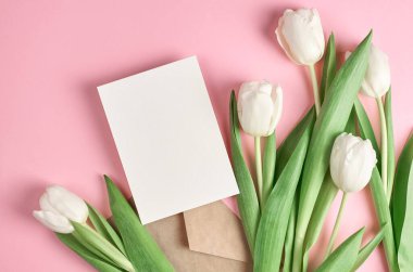 Tebrik kartı beyaz lale çiçekleri pembe kağıt arkaplan, üst görünüm, boşluk kopyala