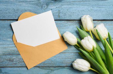 Ahşap zemin üzerinde lale çiçekleri olan tebrik kartı modeli.