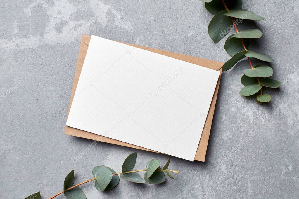 Invitation or greeting card with eucalyptus twigs on grey stony background