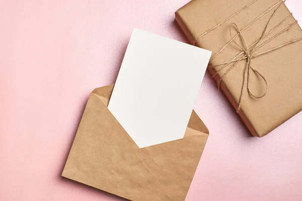 用礼品盒 手工纸信封和粉色背景的郁金香花 顶视图 复制空间进行贺卡或请柬造型 — 图库照片
