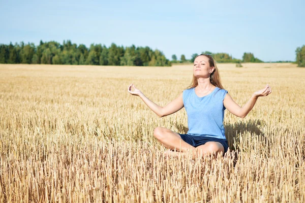 Mujer joven meditando en el campo — Foto de Stock