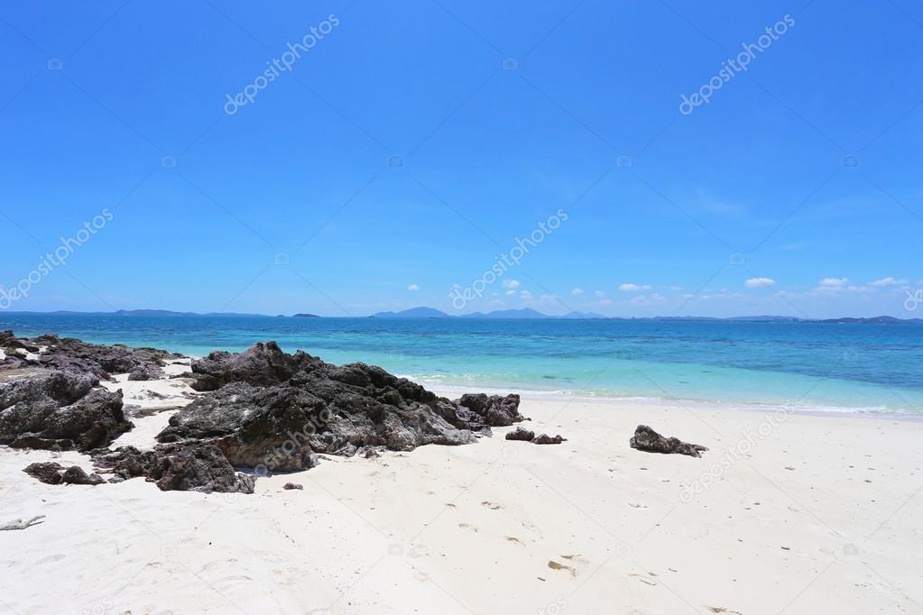 White sand beach with black stones