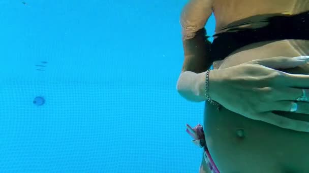 Schwangere schlägt Bally im Pool unter Wasser — Stockvideo