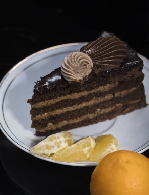 Bir dilim çikolatalı kek ve siyah bir fincanın üstünde. Nefis bir kahvaltı. Geleneksel tatlı..