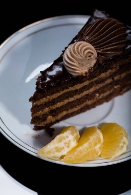 Bir dilim çikolatalı kek ve siyah bir fincanın üstünde. Nefis bir kahvaltı. Geleneksel tatlı..