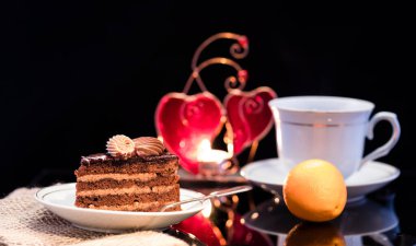 Bir dilim çikolatalı kek ve siyah bir fincanın üstünde. Nefis bir kahvaltı. Geleneksel tatlı..