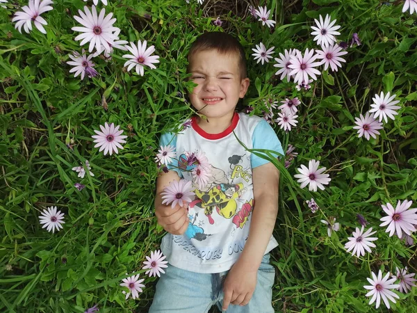 Çocuk çiçeklerin içinde yatıyor.