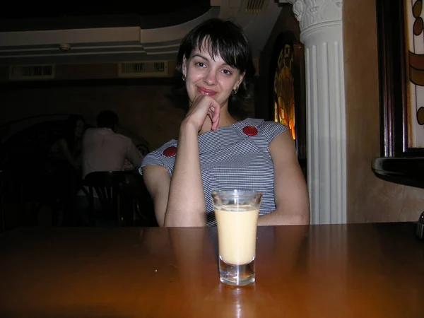 Kafede bir bardak likör içen bir kız.