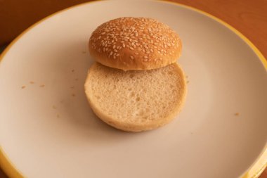 Susamlı hamburgerin yarısı hazır.