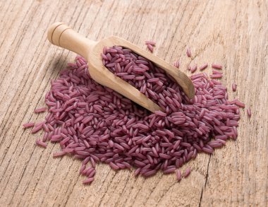 Purple rice on wooden background clipart
