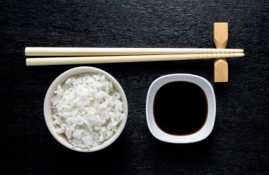Japon suşi yemek çubukları soya sosu kase, pirinç üzerine siyah bac üzerinde