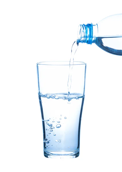 Water uit de fles in glas gieten — Stockfoto