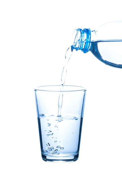 Water uit de fles in glas gieten — Stockfoto