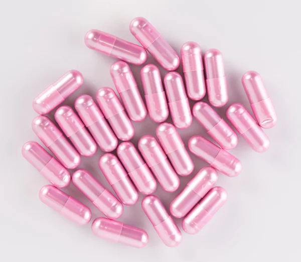 Cápsulas píldora rosa sobre fondo blanco —  Fotos de Stock