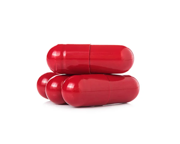 Cápsulas comprimidos vermelhos sobre fundo branco — Fotografia de Stock