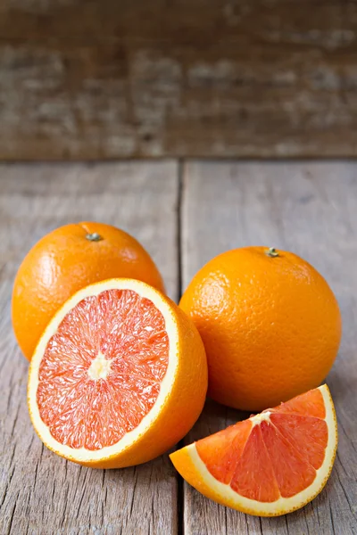 Frische Orangen mit Scheiben auf Holzgrund. Stockbild