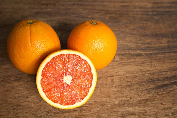 Frische Orangen mit Scheiben auf Holzgrund. Stockfoto