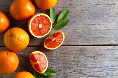 Taze portakal dilimleri ve ahşap arka plan üzerinde yaprakları ile.