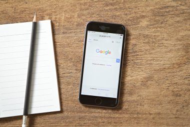 Bangkok, Tayland - 22 Şubat 2016: Yeni gri iphone 6 gösteren google Web sitesinde ekran ahşap masanın üstüne koy. en popüler akıllı telefonlar iPhone 6 olduğunu.