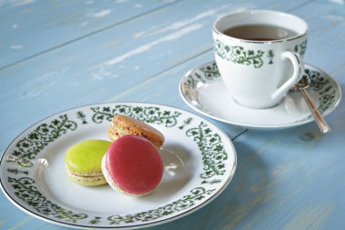 Macarons ahşap tabloda çay ile.