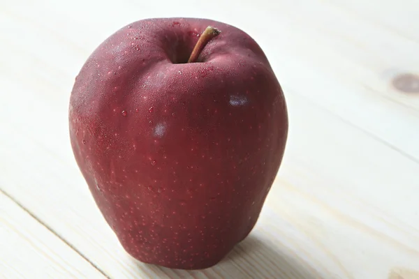 Червоне яблуко з росою на фоні дерева — стокове фото