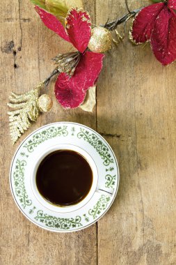 Ahşap tahta arka plan üzerinde kırmızı çiçekli kahve