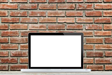Tuğla duvar arka plan ile masada dizüstü bilgisayar.