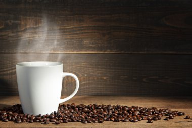 Ahşap arka planda kahve fincanı ve kahve çekirdeği..