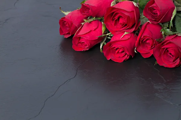 Rosas rojas sobre fondo de piedra negra. Fondo del día de San Valentín . — Foto de Stock