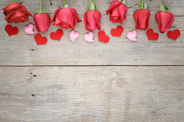 Rosen mit rotem und rosa Herz auf hölzernem Hintergrund. Valentin 's lizenzfreie Stockfotos