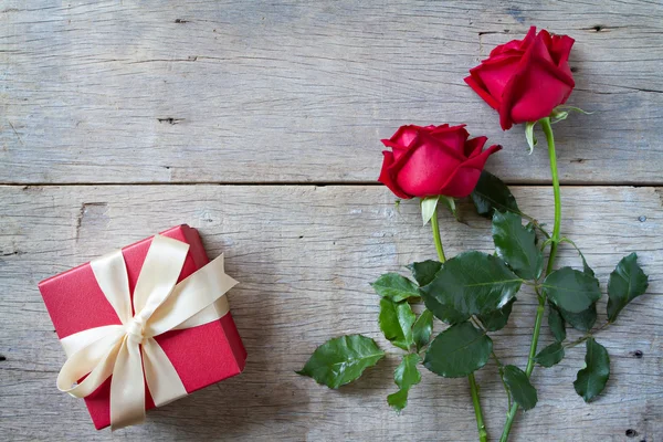 Rosas vermelhas com caixa de presente vermelha no fundo woonden. Dia dos Namorados — Fotografia de Stock