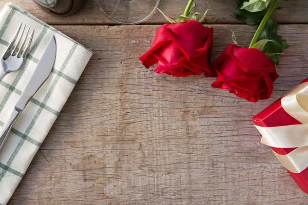 Yemek masası üzerinde hediye kutusu ile kırmızı gül. Sevgililer günü, anniv — Stok fotoğraf