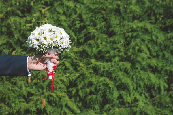 Brudgummen håller brudbukett — Stockfoto