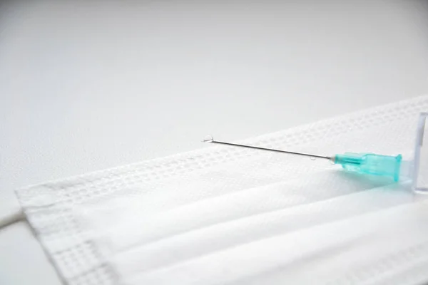 Maske. Şırınga ve iğne. Beyaz arka plan. Bırak