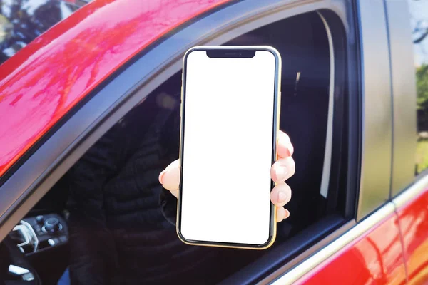 Pencere arabasının dışında akıllı telefon gösteren kadın.