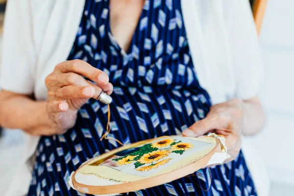 Closeup of old woman sew