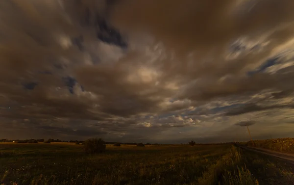 Облака небо ночное поле время истекает — стоковое фото