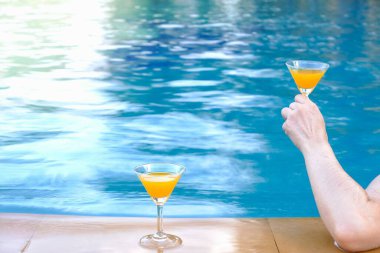 Havuz kenarında içki içen bir kadının yakın çekimi, yaz mevsiminde mutlu bir hayat.