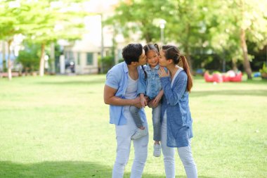 Mutlu Asyalı aile kızıyla birlikte parkta.