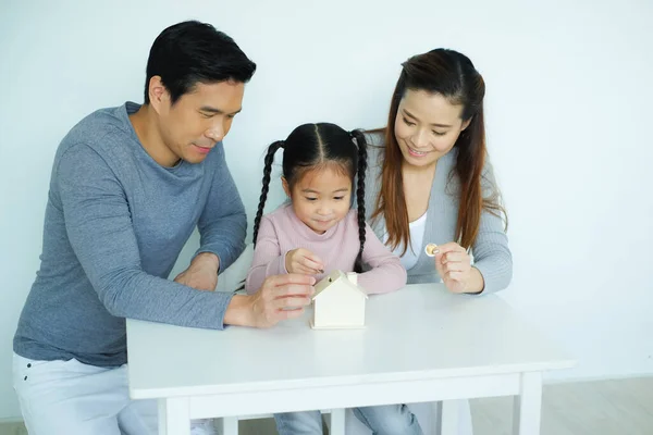 stock image Asian family, father mother and daughter together saving money