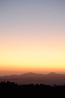 Gün doğumu gökyüzü ve dağ, dikey resim