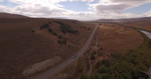 Воздушный беспилотный горный маршрут, вид на реку и проезжающий мимо грузовик — стоковое видео