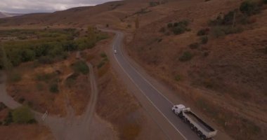 Hava dron dağ rota sahne, tarafından geçen otomobil ve kamyon takip kamera.