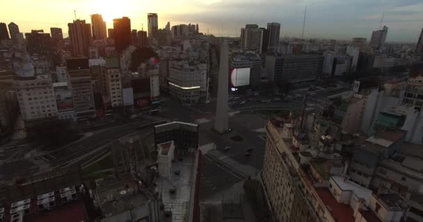 Aerial Drone scen av obelisken i Buenos Aires, Argentina, vid soluppgången på morgonen. Flytta bakåt från Obelisken genom Diagonal Norte Street. — Stockvideo