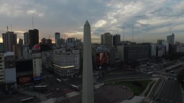 Dikilitaş Buenos Aires, Arjantin, hava uçak olay yerinde sabah gündoğumu. 9 de Julio ana Avenue, 9 Temmuz. Trafik ve insanlar gidiş çalışmak. Kamera geriye doğru çapraz Norte Caddesi hareket seyahat hava.