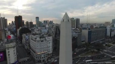 Dikilitaş Buenos Aires, Arjantin, hava uçak olay yerinde sabah gündoğumu. 9 de Julio ana Avenue, 9 Temmuz. Trafik ve insanlar gidiş çalışmak. Kamera hava kaydırma.