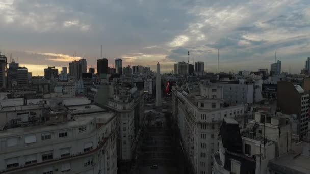 Aerial Drone scen av obelisken i Buenos Aires, Argentina, vid soluppgången på morgonen. Kamera antenn reser framåt genom Diagonal Norte Street. — Stockvideo