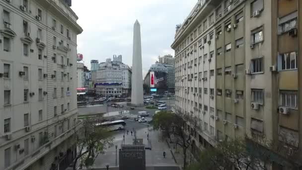 Aerial Drone scen av obelisken i Buenos Aires, Argentina, vid soluppgången på morgonen. 9 de Julio main Avenue, 9 juli. Trafik och människor. Resa går framåt genom Diagonal Norte Street. — Stockvideo