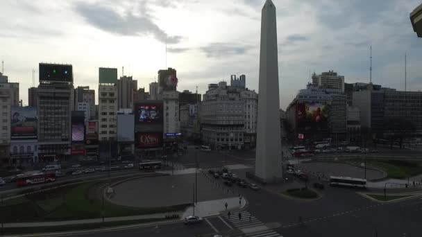 Drone aereo scena di Obelisco a Buenos Aires, Argentina, all'alba del mattino. 9 de Julio viale principale, 9 luglio. Traffico e persone. Fotocamera panning aerea ascendente in movimento verticale . — Video Stock